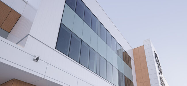 Détail de la façade hybride du siège social Jefo, panneaux métalliques et vitrages STE-6000.