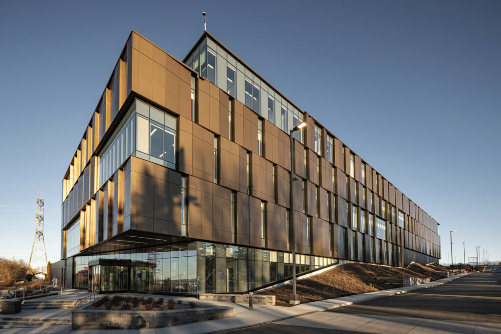 Side view of Québec City Central Police Station with large glass partitions and bronze cladding.
